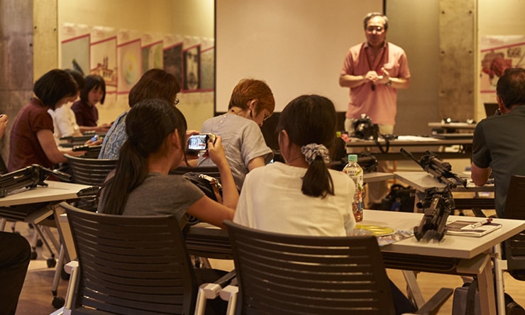 熱心に耳を傾け、メモをとったりカメラを操作したり。なかには小学生の姿も ©金 成津