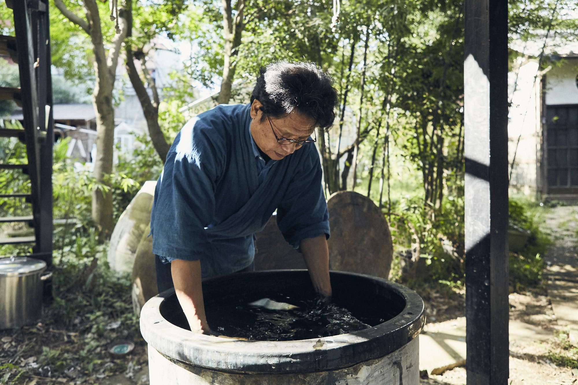 緑の中、流れるような作業で布を染めていく