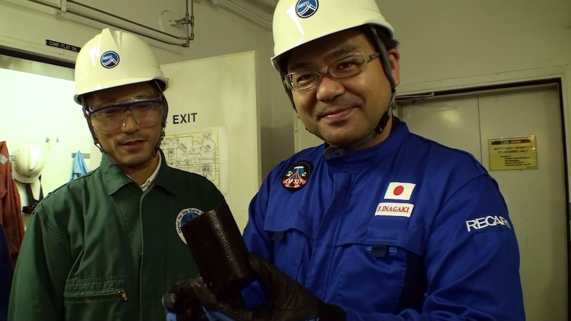 稲垣さんが手にしているのは、八戸沖の海底下2,000mから採取した直後の石炭層のサンプル。掘削調査では「コア」と呼ばれる円筒形の地層サンプルが採取される ©︎JAMSTEC/IODP