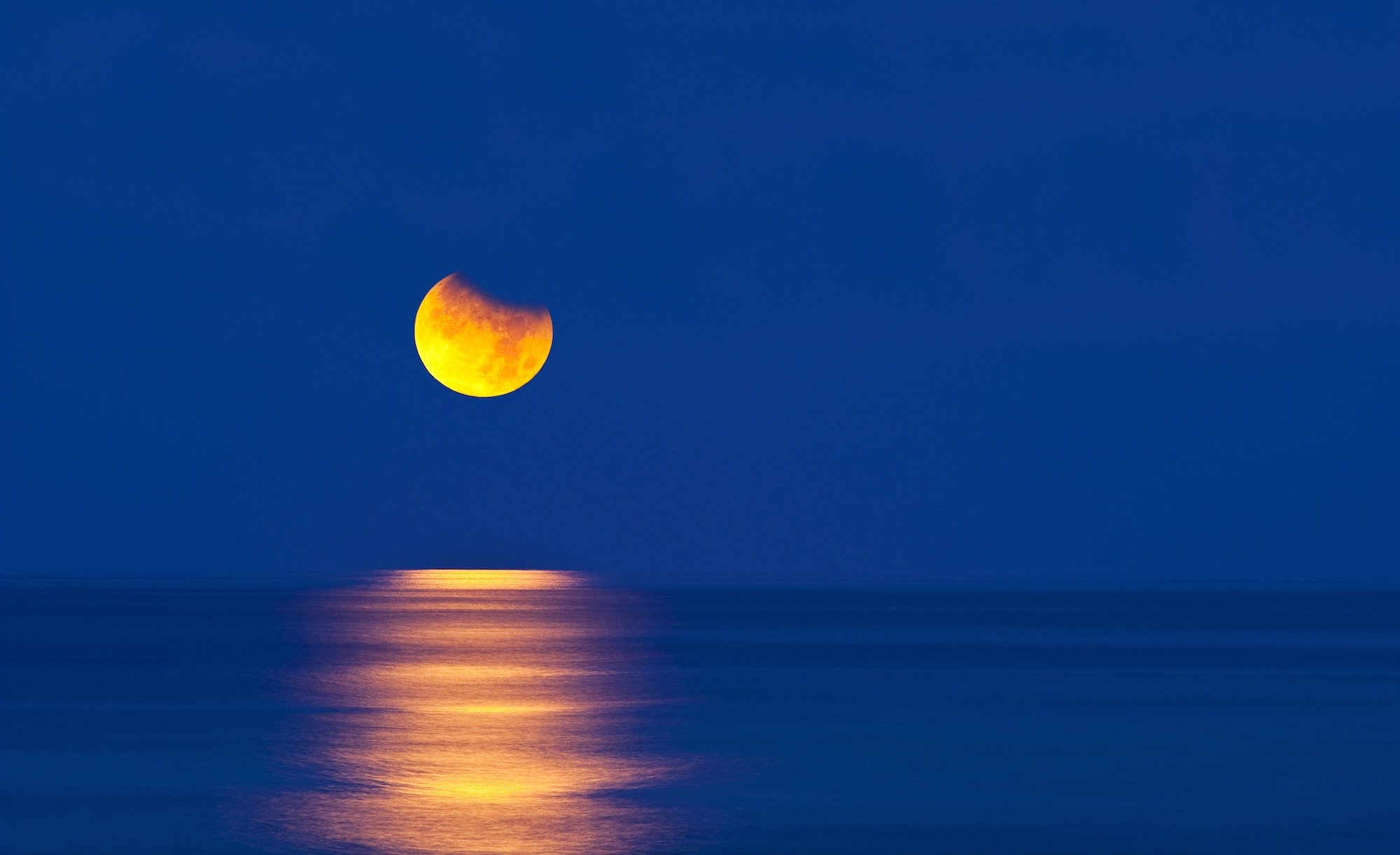 海に沈んでいく月 ©DAVID NUNUK/SCIENCE PHOTO LIBRARY /amanaimages