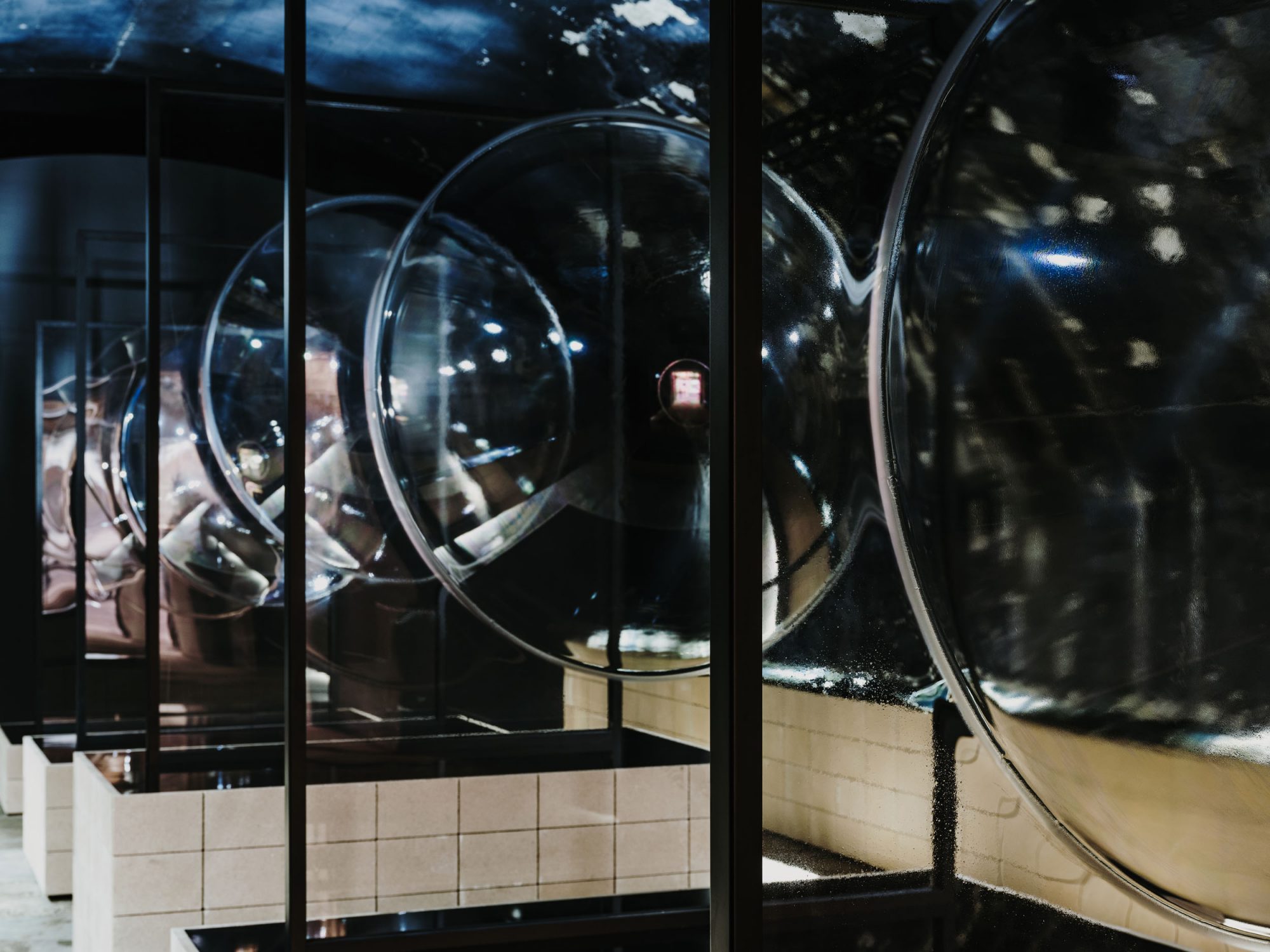 縦置きに置かれた5枚のガラス。1枚あたりの大きさは2,600mm x 1,943mm 、重さ120kg。そこに、直径約1,600mmの円を描き、それぞれ100mm、200mm、400mm、600mm、800mmの曲げ重量を与えた ©︎AGC Inc.