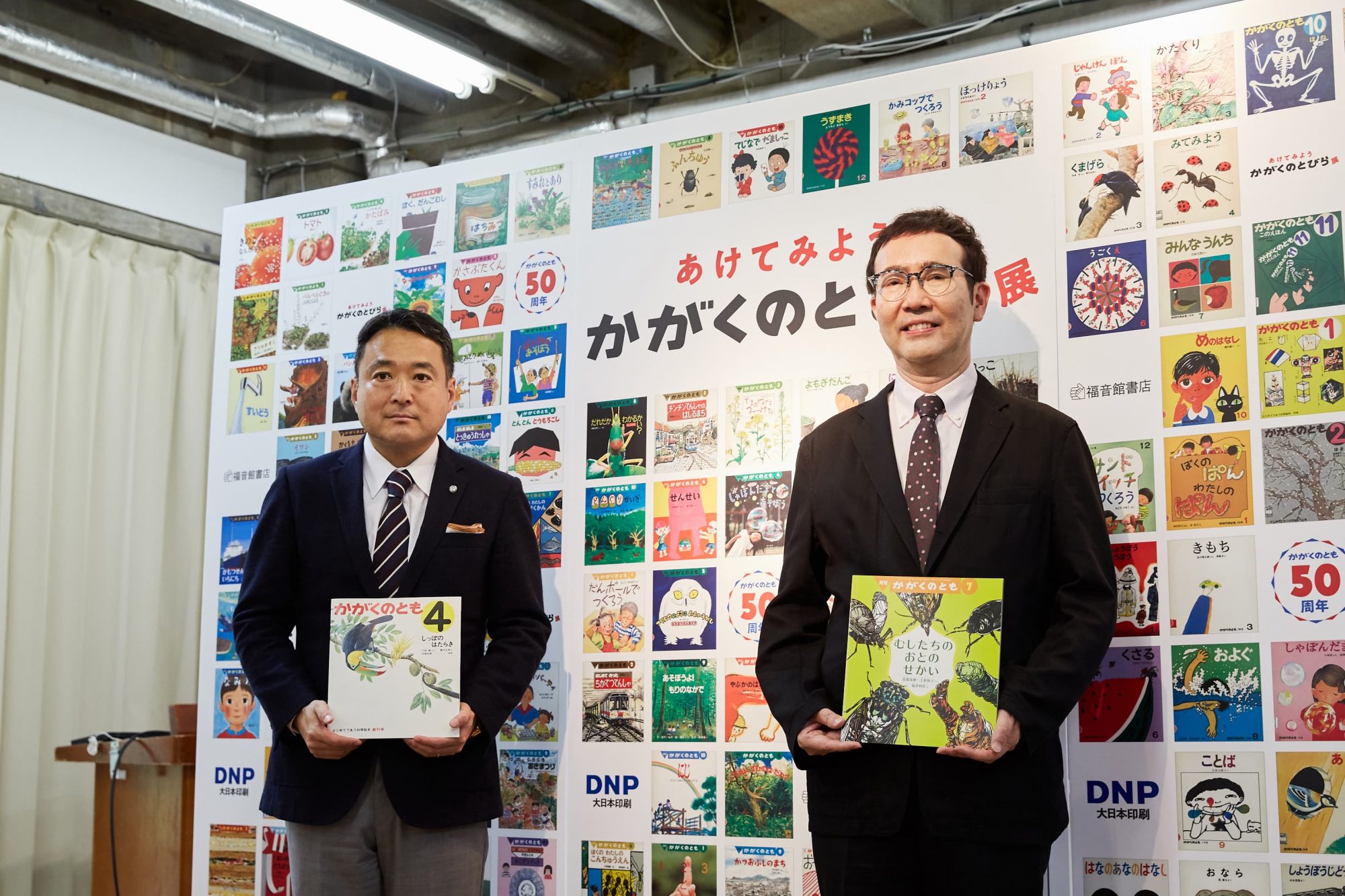 福音館書店の佐藤潤一社長（左）と、展覧会の監修を務めた生物学者／青山学院大学教授の福岡伸一さん（右）。福岡さんは、大人に比べて優れた五感を持つ子どもたちに対して、この世界に対する「眼の凝らしかた、耳の澄ませかた、鼻の近づけかた」を伝え、科学への扉を開くことが「良質な科学絵本が果たす意義」だと述べました