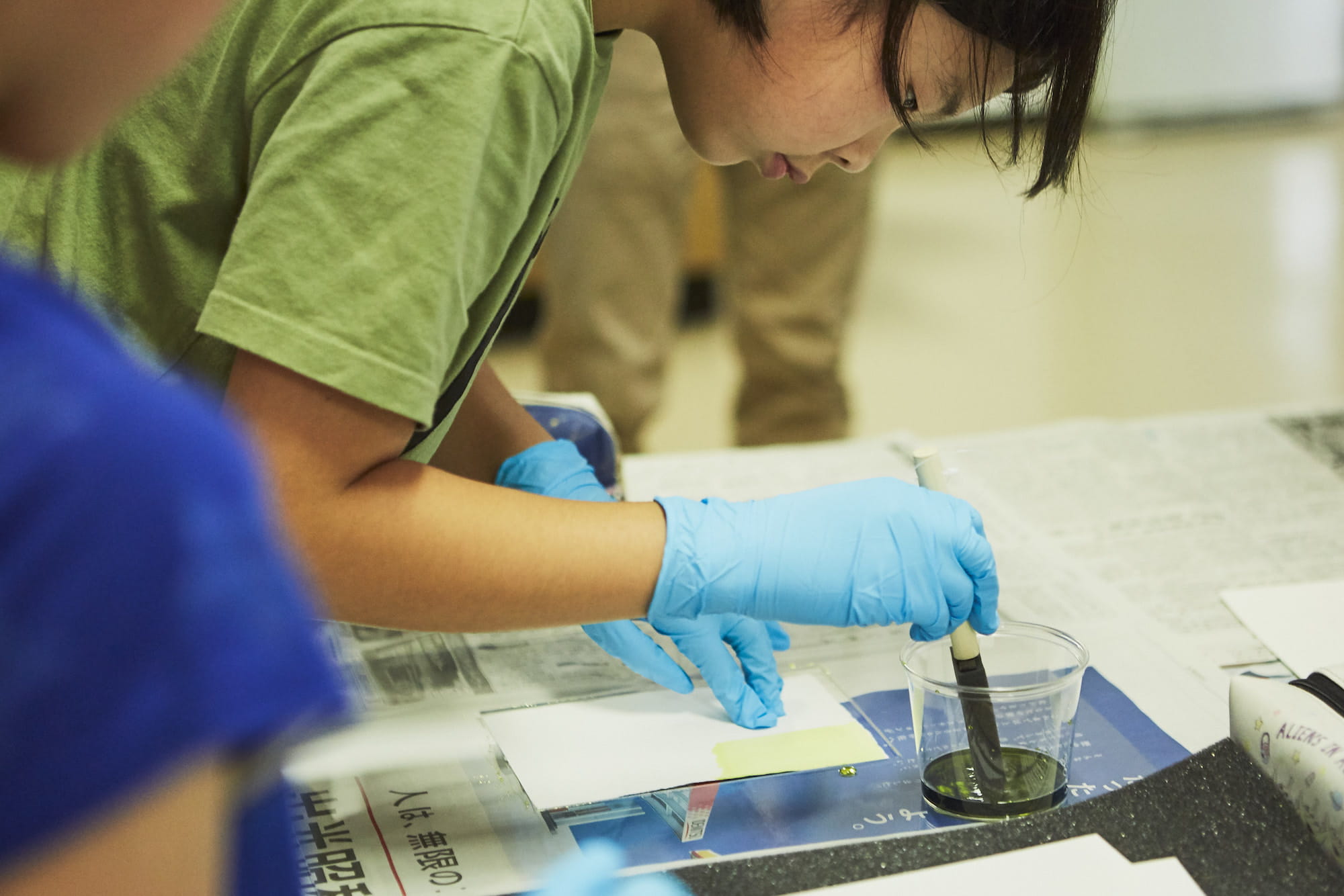 スポンジに感光液（シュウ酸鉄アンモニウム）と現像液（フェリシアン化カリウム）を混合した薬品を含ませ、紙全体に塗っていきます