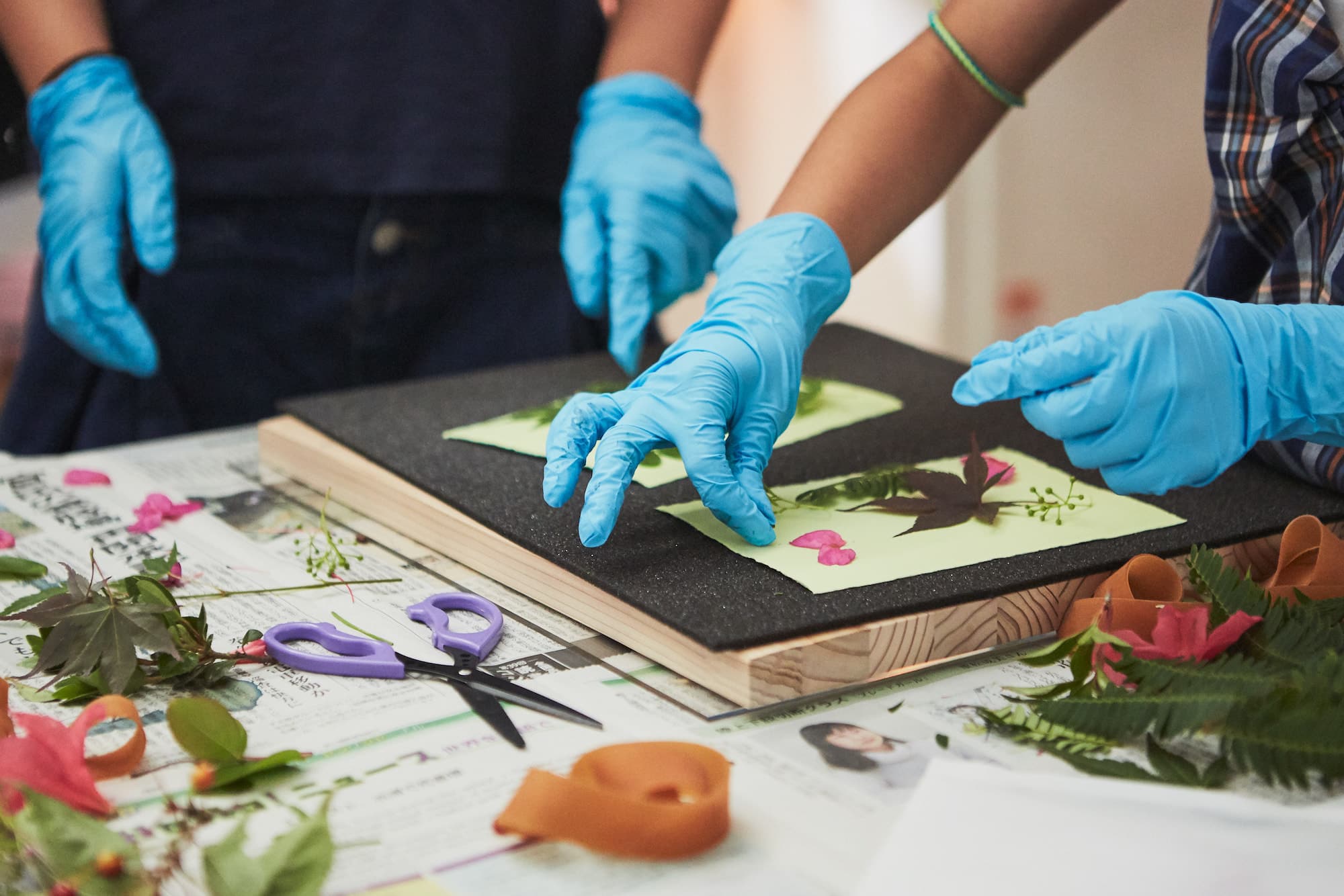 ふたりで協力して作品をアクリル板で挟み、太い輪ゴムでとめます。その後、太陽の下へ