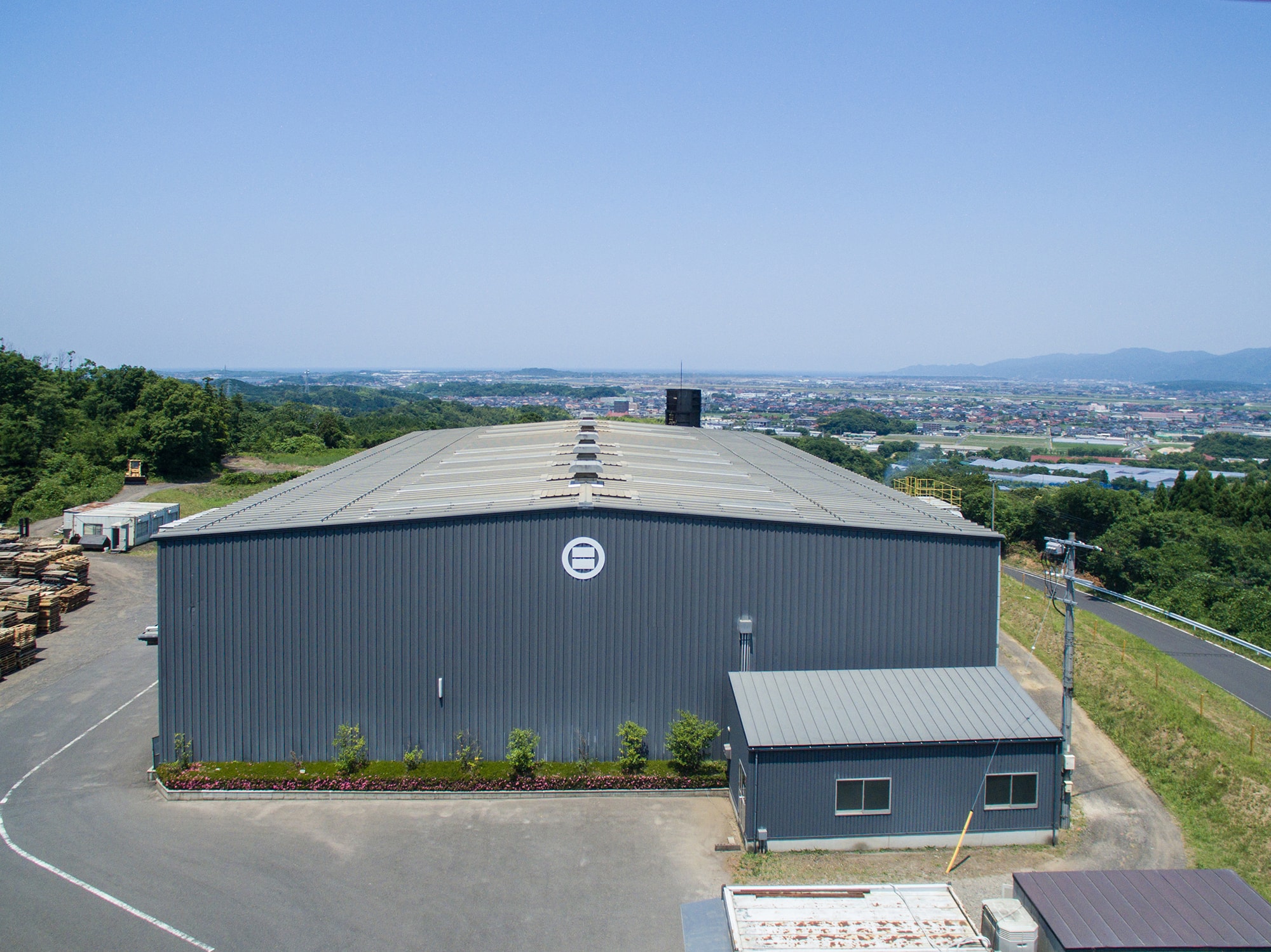 緑豊かな出雲市郊外に建設された日本最大級のリサイクル炭化プラント。ここで年間9,000tの木材がリサイクルされる （写真提供：出雲土建）