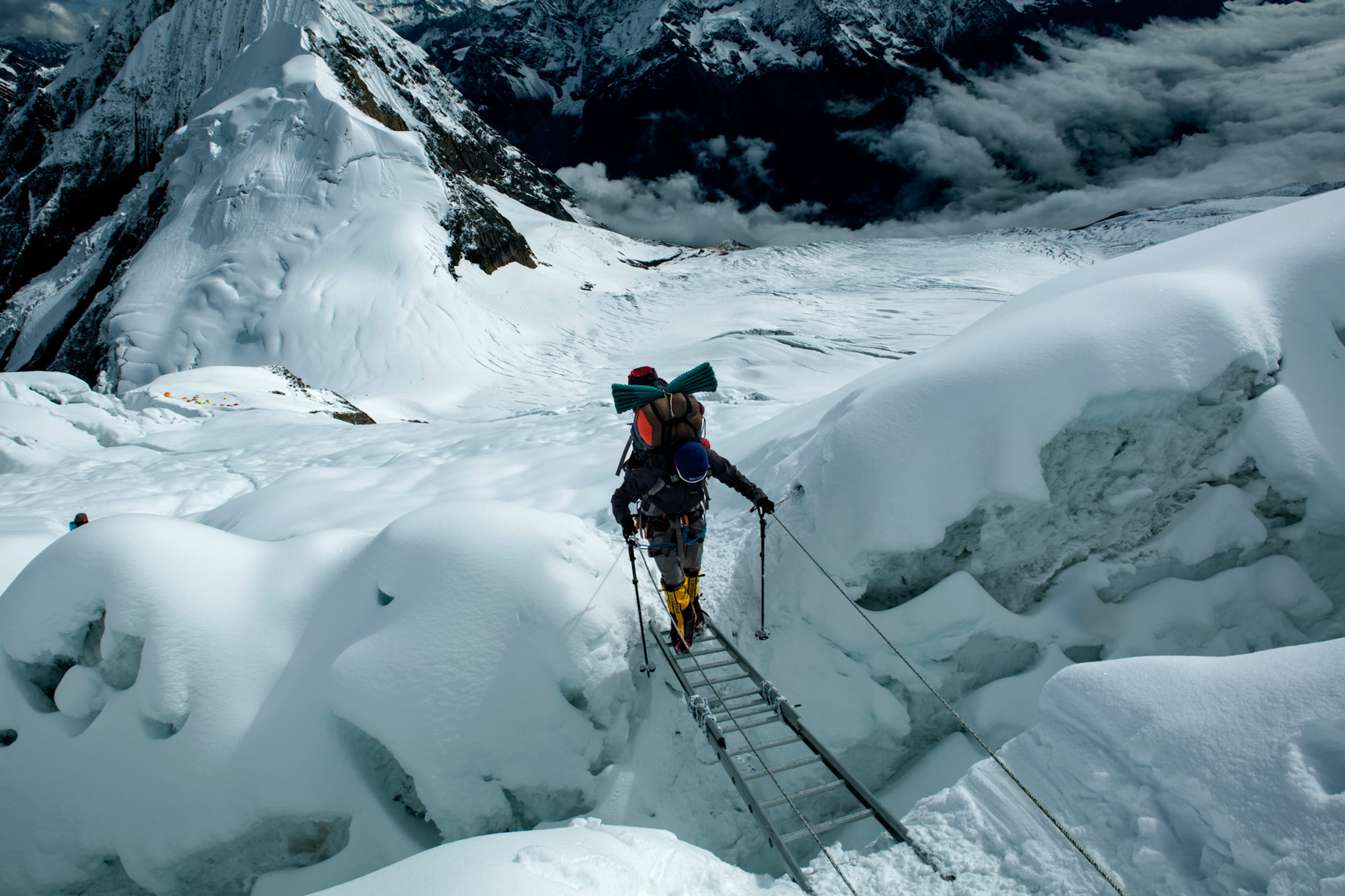 クレバスは、雪渓や氷河に空いた深い割れ目。雪に覆われて見えないこともある。はしごをかけて慎重に進む