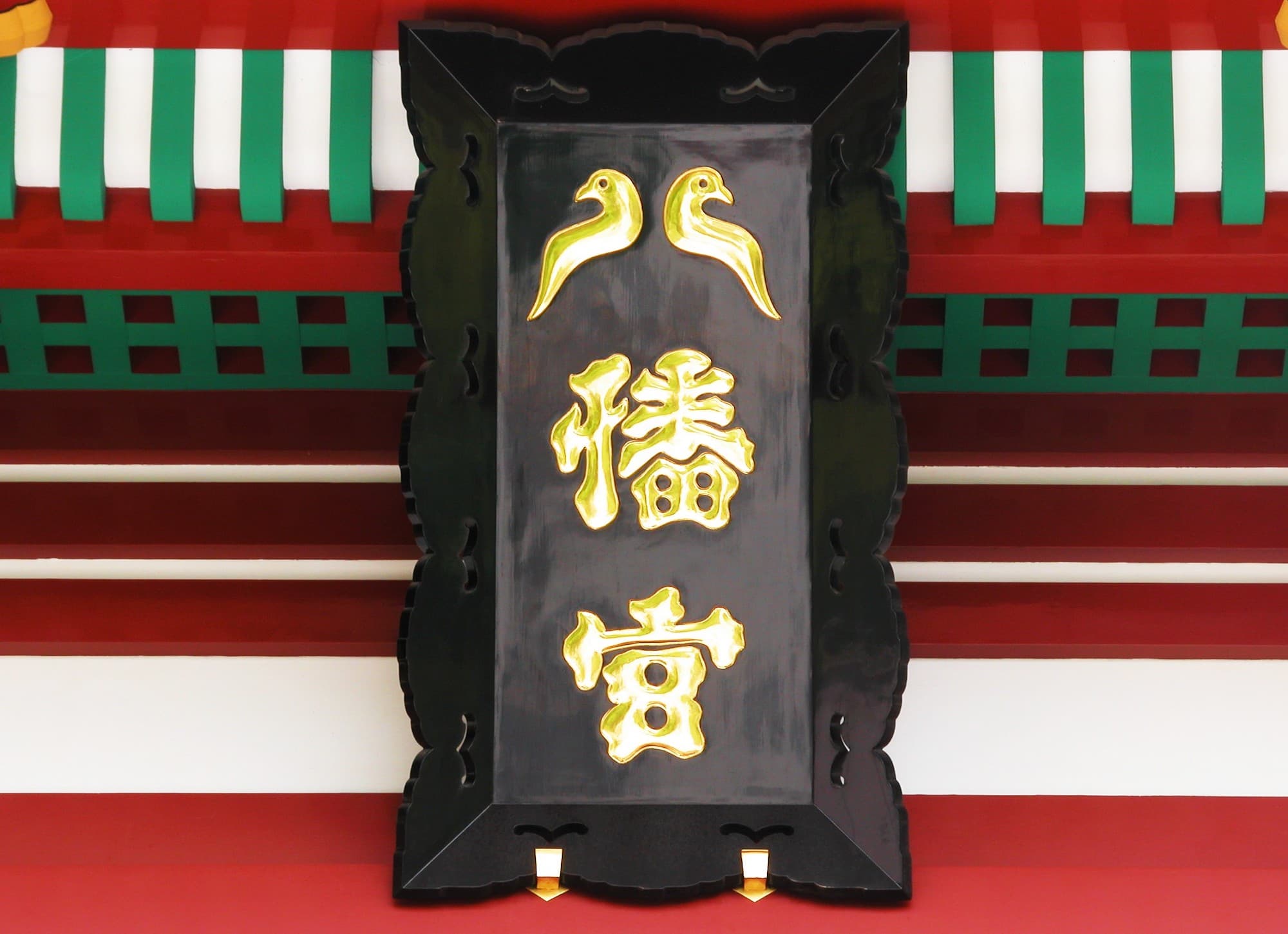 八幡宮の扁額の「八」の字は、神様のお使いのハトをかたどる