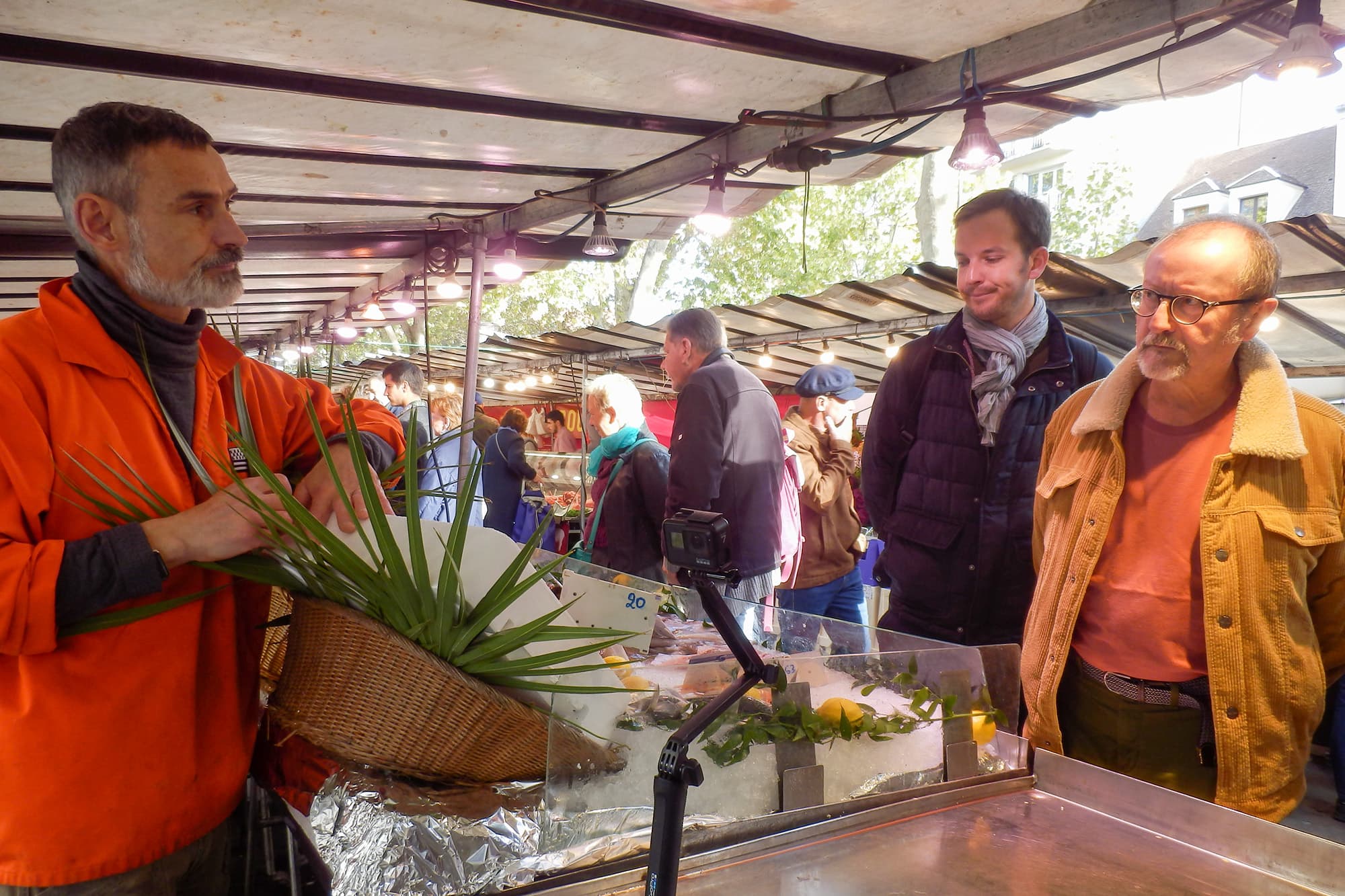マルシェで「活け締め」の説明をするエルワンさんと、熱心に見入るお客さん
