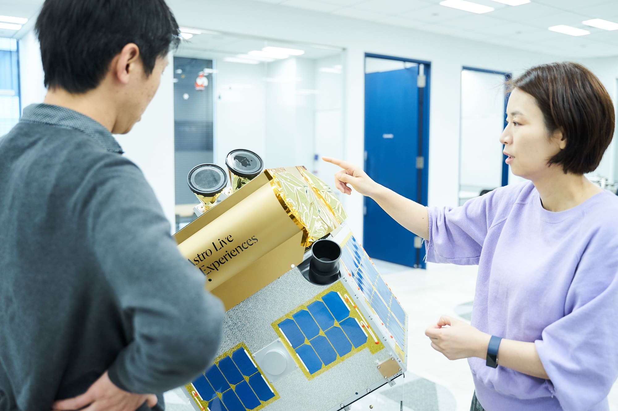 ALEの人工衛星2号機「ALE-2」の模型を前に。対談は一時帰国した小野さんをALEの新オフィス（東京・大門）に迎えて収録