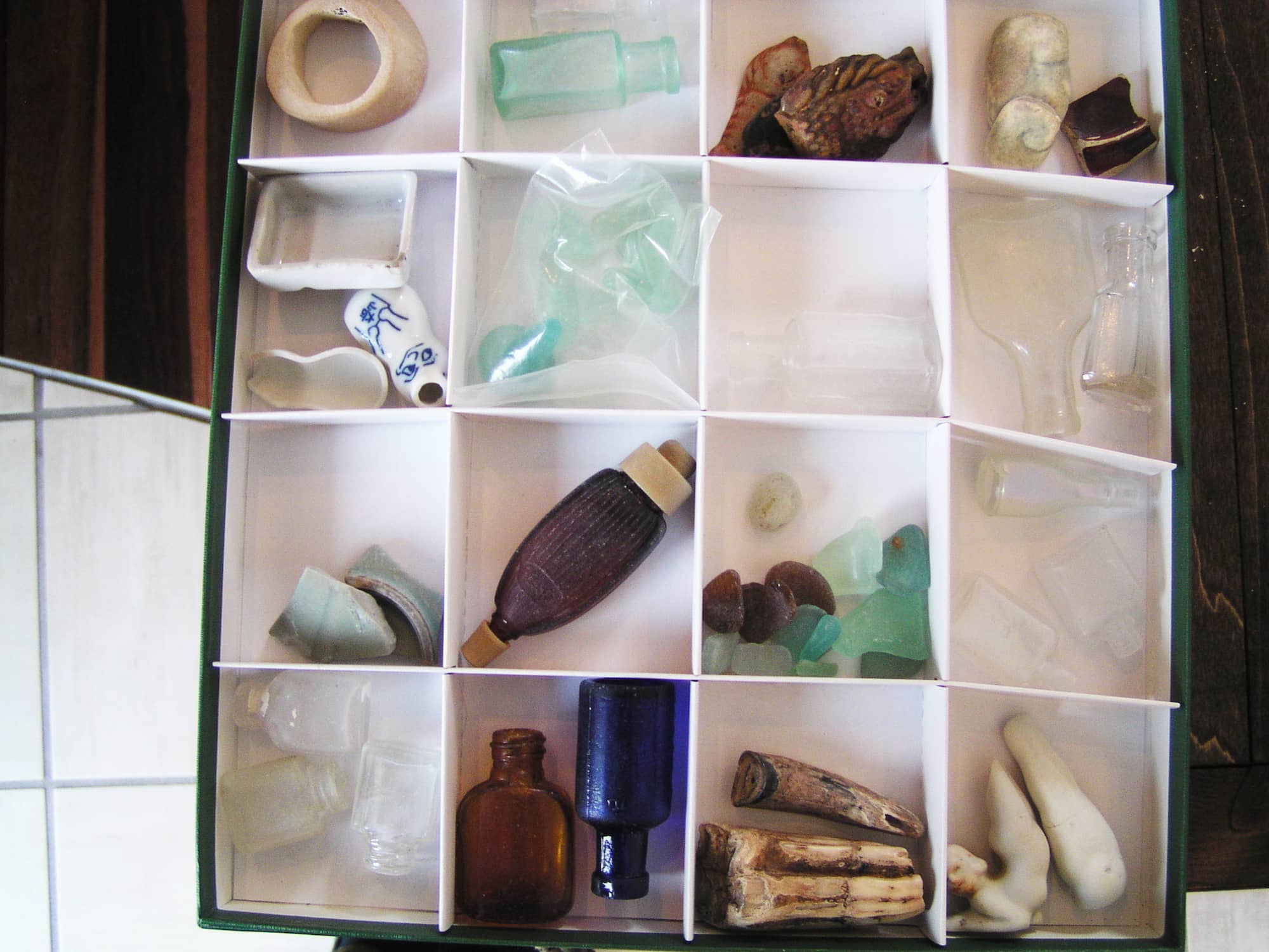 ビーチコーミングで見つかった漂着物。鎌倉時代のものらしい馬の歯や中国・宋から持ち込まれたと思われる青磁のかけら、海底で砂に埋もれているうちに虹色の輝きを放つようになる「銀化ビン」などの貴重な「お宝」が並ぶ。2008年「鎌倉ビーチコーミング」展の展示より