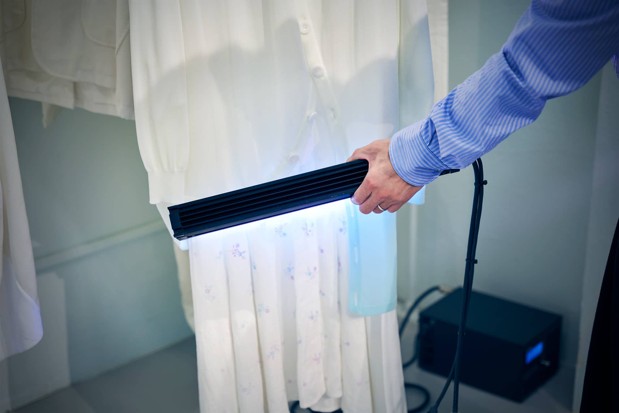 コレクション「光合成（PHOTOSYNTHESIS）」より、太陽光で変色する「フォトクロミックガーメント」に紫外線ライトを当てる